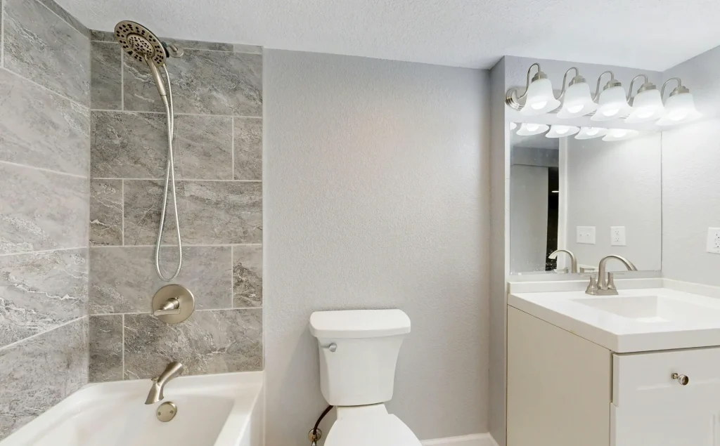 Modern gefliestes Badezimmer mit hochwertig abgedichteter Dusche.